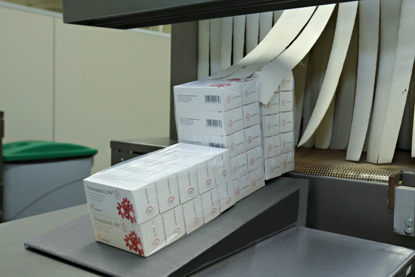 White pharmaceutical boxes on a conveyor belt system.