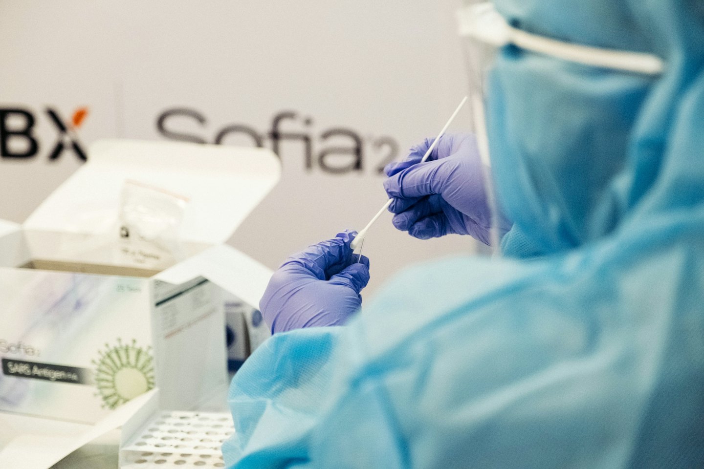 Healthcare worker prepares nasal swab for diagnostic test.